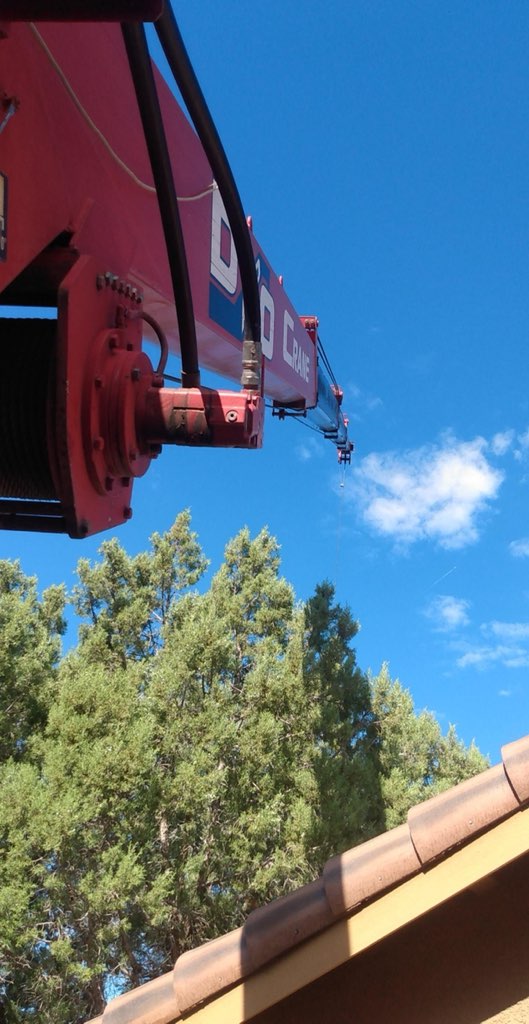 D&O Crane boom extending above a residential roofline in Northern Arizona.
