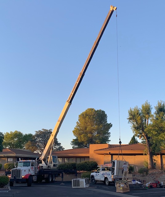 Mobile crane lifting HVAC unit at a commercial building in Cottonwood AZ by D&O Crane.